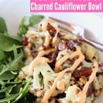 Cauliflower and arugula in bowl with fork