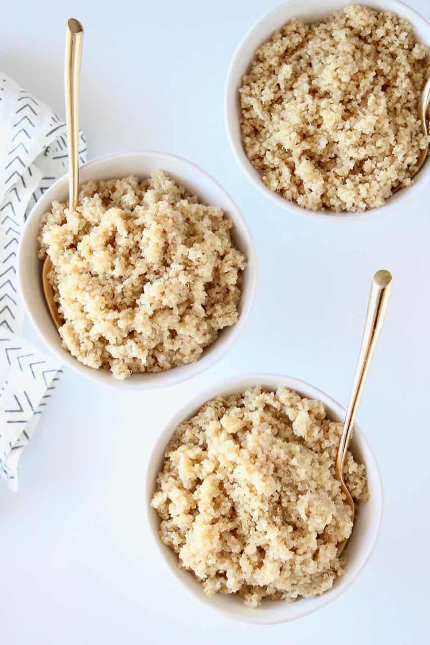 three bowls of quinoa with gold forks