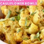 Roasted cauliflower in bowl topped with yellow curry sauce