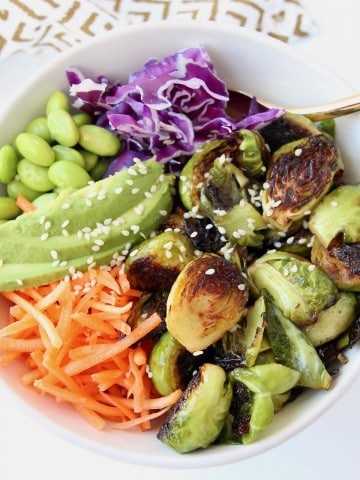 Overhead image of bowl with crispy brussels sprouts, carrots, avocado and cabbage