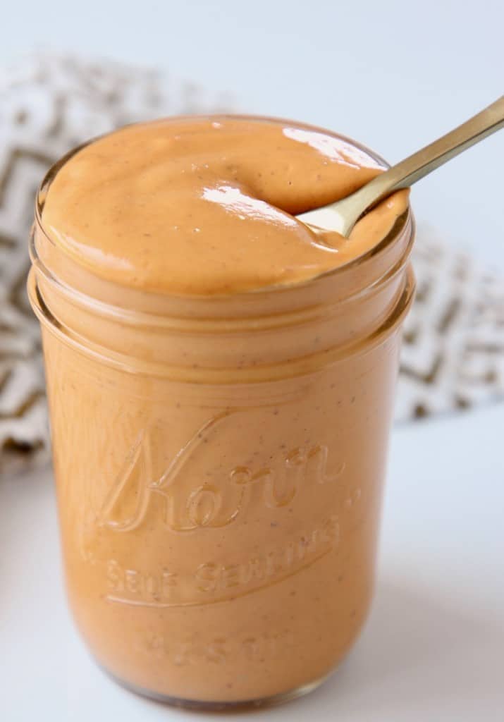 Creamy chipotle sauce in mason jar with small gold spoon