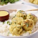 Meatballs in bowl with rice and yellow curry sauce