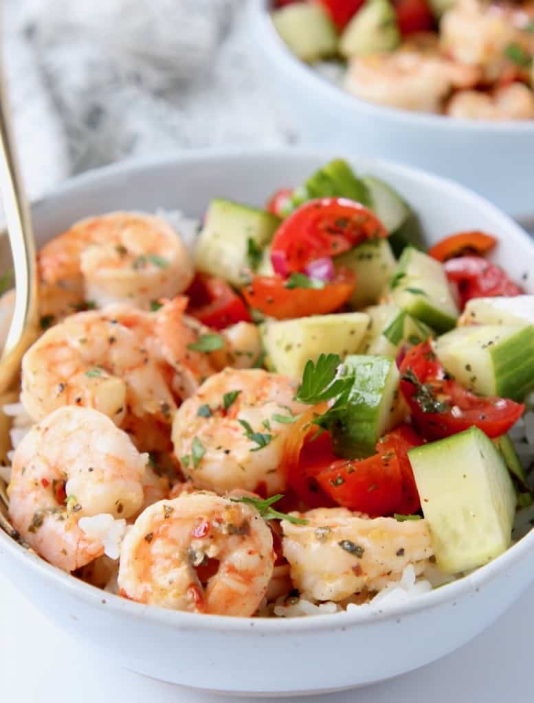 Shrimp in bowl with diced cucumber and tomato