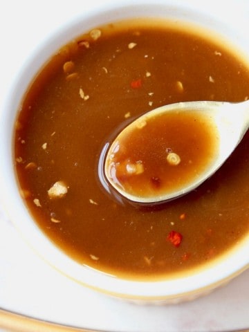 Overhead image of sesame sauce in bowl with gold spoon of sauce coming out of the bowl