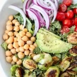 Cobb salad with seared brussels sprouts in bowl with copper forks