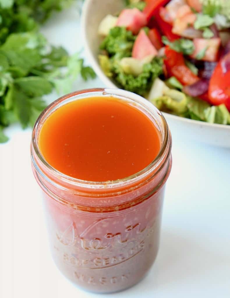 Chipotle vinaigrette dressing in mason jar with salad behind it in bowl