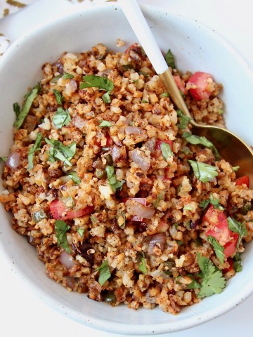 Overhead image of Mexican spiced cauliflower rice in bowl with spoon