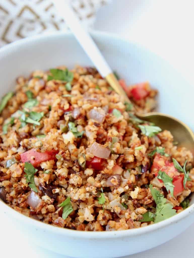 Mexican style cauliflower rice in bowl with spoon