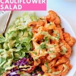 Overhead image of buffalo cauliflower in bowl with lettuce and shredded cabbage