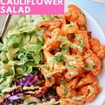 Overhead image of buffalo cauliflower in bowl with lettuce and shredded cabbage