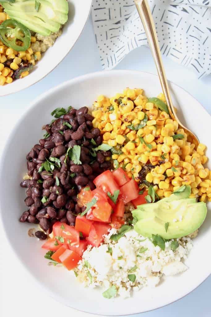 Overhead image of bowls with black beans, corn, tomatoes and avocado