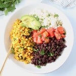 Overhead image of bowl filled with black beans, corn, diced tomatoes, avocado and quinoa
