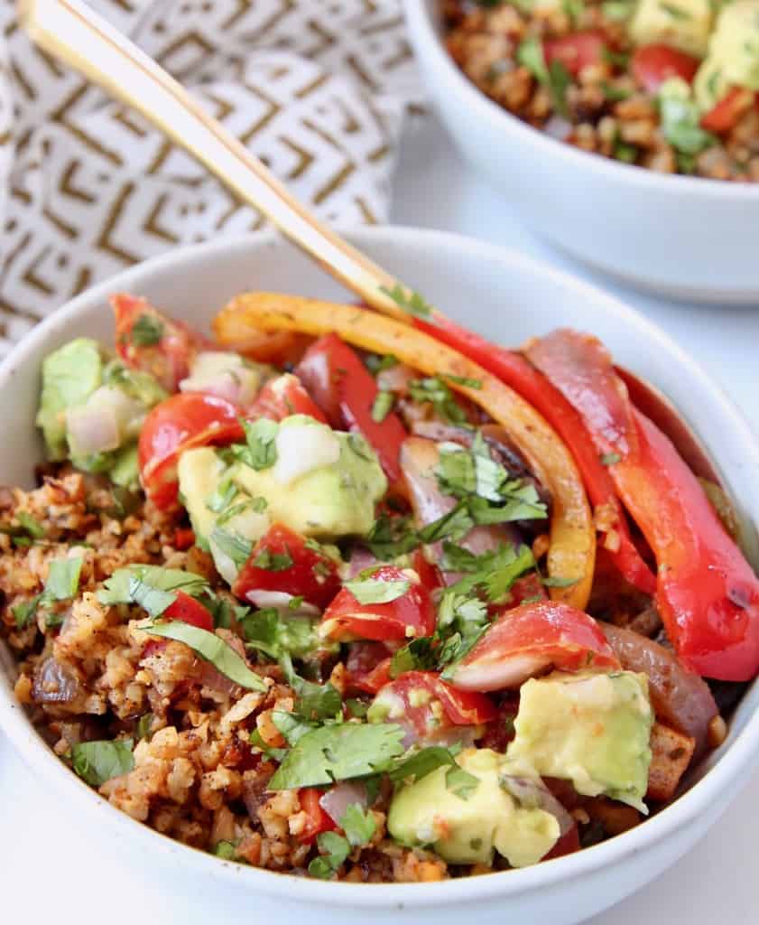 Bell pepper fajitas in bowl with avocado and roasted cauliflower rice