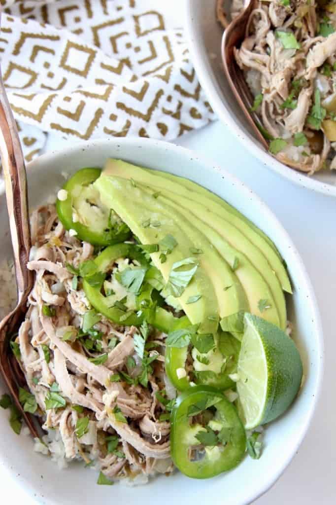 Overhead image of pulled pork in bowl with avocado and sliced jalapenos