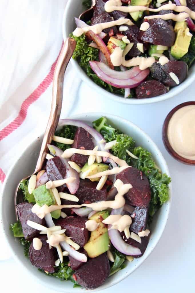 Overhead image of kale beet salad, topped with a drizzle of tahini dressing