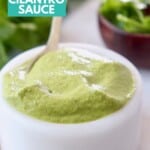 spicy cilantro sauce in white bowl with gold spoon