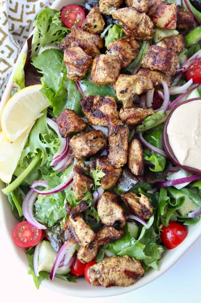 overhead image of grilled chicken on salad