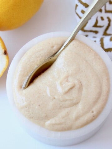 overhead image of tahini sauce in small bowl with spoon