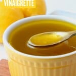lemon vinaigrette dressing in yellow bowl with gold spoon