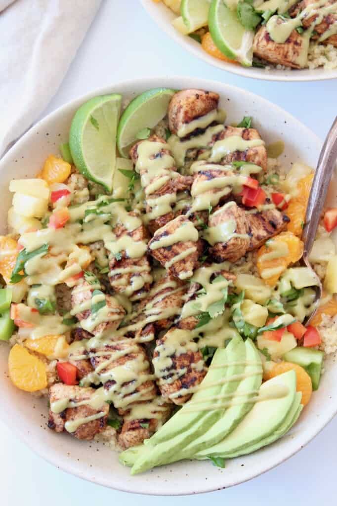grilled chicken in bowl with honey lime dressing drizzled over the chicken
