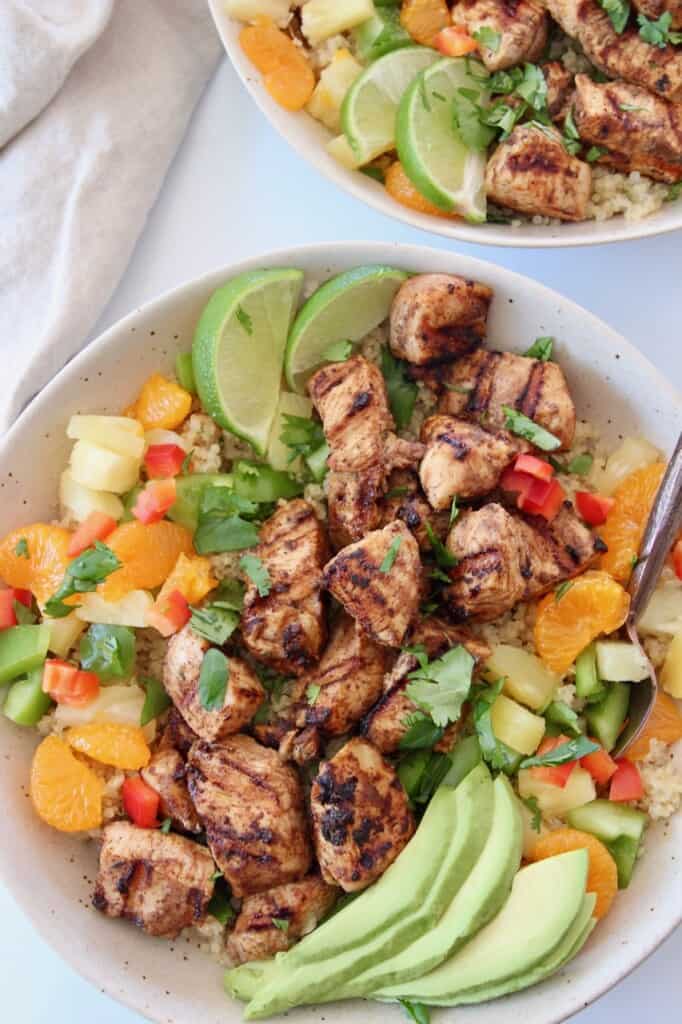 grilled diced jerk chicken in bowl with fresh fruit and vegetables