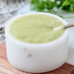honey lime salad dressing in small white bowl with spoon