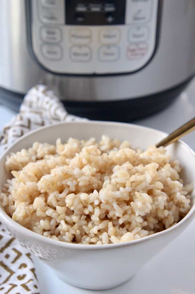 bowl of cooked brown rice sitting in front of an Instant Pot
