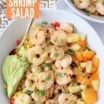 cooked shrimp on salad in bowl topped with honey lime salad dressing