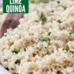 cooked quinoa in bowl with wooden spoon and lime wedge