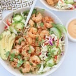grilled shrimp in bowl with greens