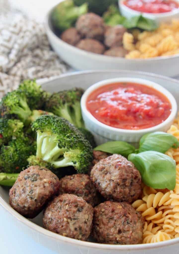 vegan meatballs in bowl with broccoli and marinara sauce