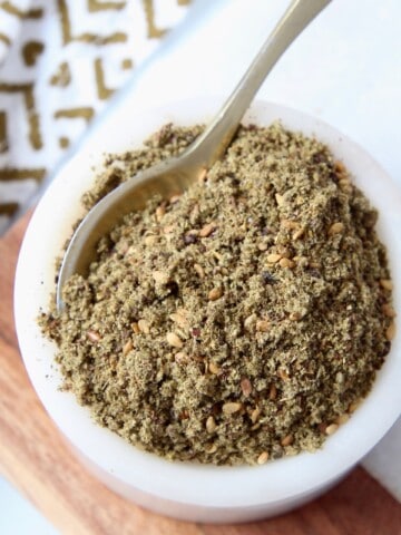 zaatar seasoning in white bowl with small spoon
