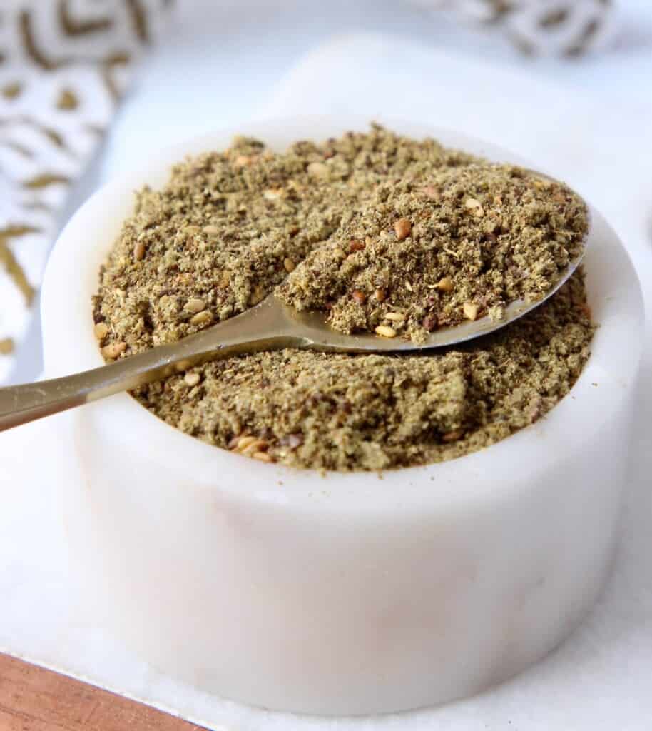 spoon of za'atar seasoning blend in small white bowl