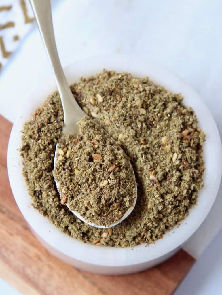 zaatar seasoning in white bowl with small spoon