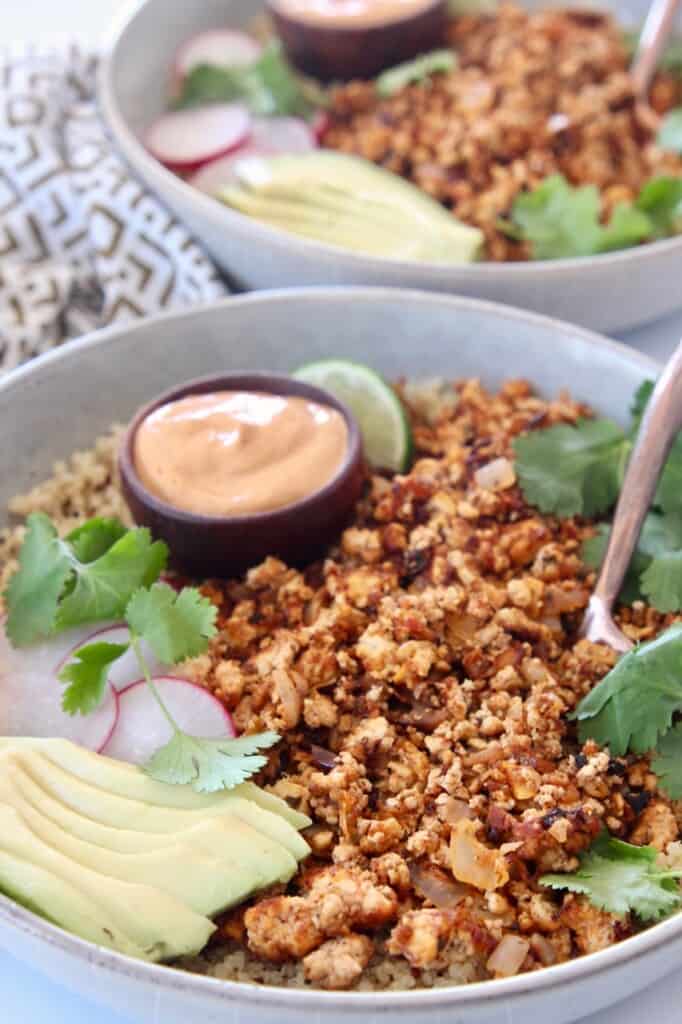 crumbled tofu taco meat in bowl with sliced avocado and creamy chipotle sauce
