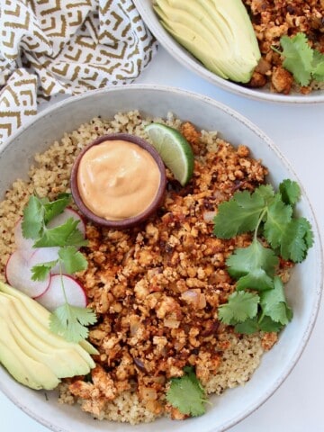 cooked crumbled tofu in bowl with quinoa and sliced avocado
