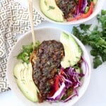 spicy baked cod in bowl with sliced avocado and slaw