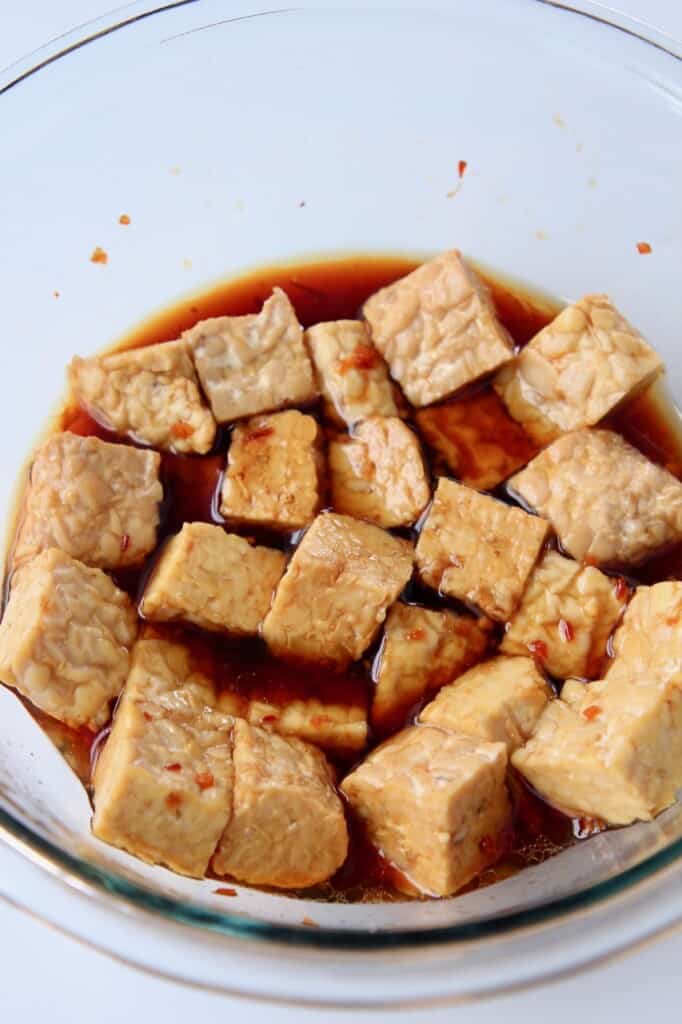 cubed temeph in marinade in glass bowl