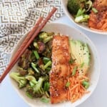 teriyaki salmon in bowl with sliced avocado and roasted vegetables