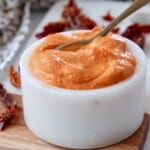 creamy sun dried tomato sauce in white bowl with spoon