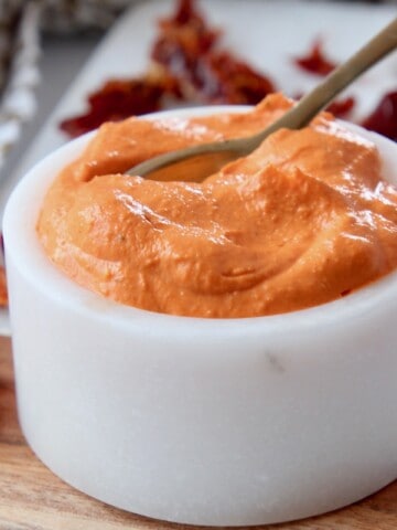 creamy sun dried tomato sauce in white bowl with spoon