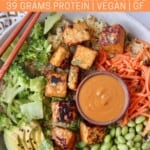 cooked tempeh in bowl with vegetables and peanut sauce