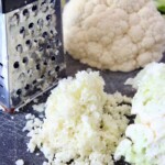 cauliflower rice on cutting board next to box grater