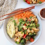 chicken and vegetable teriyaki bowl with sliced avocado and chopsticks