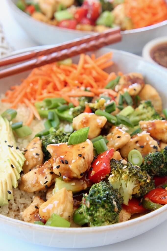 teriyaki chicken and vegetables in bowl with chopsticks