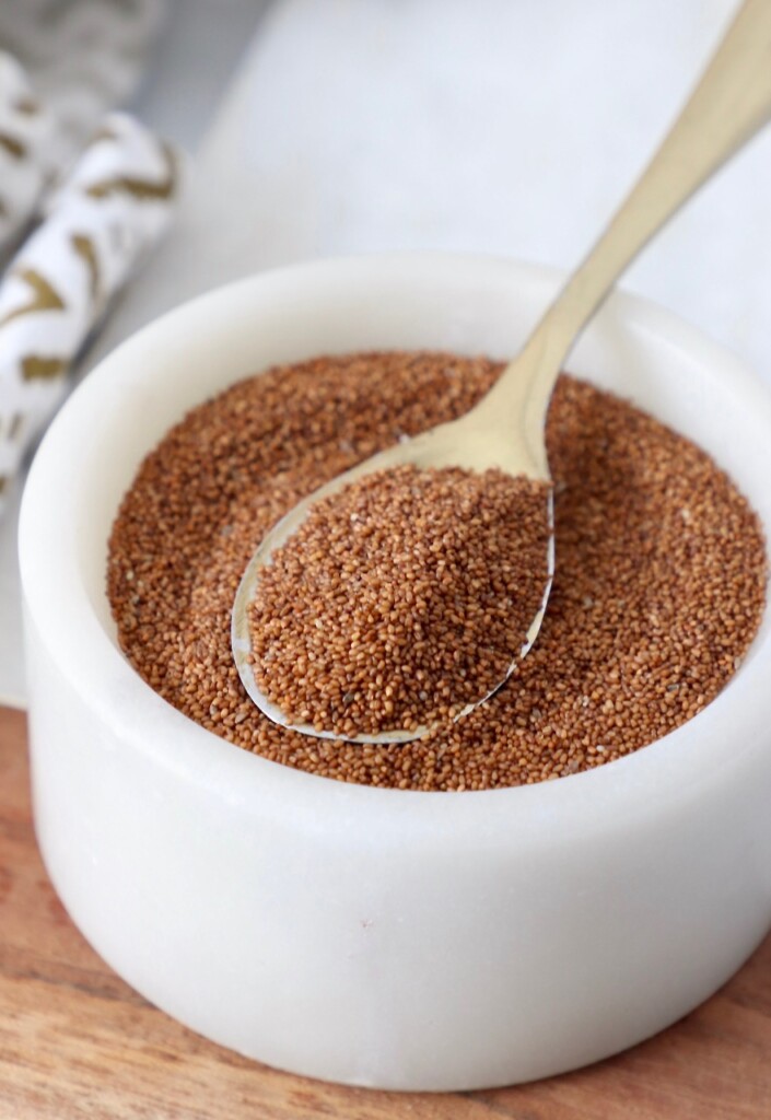 uncooked teff in bowl with small spoon