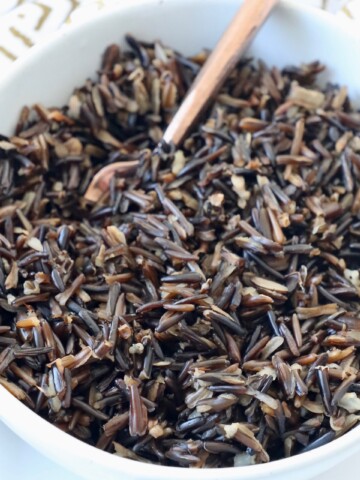 cooked wild rice in bowl with copper fork