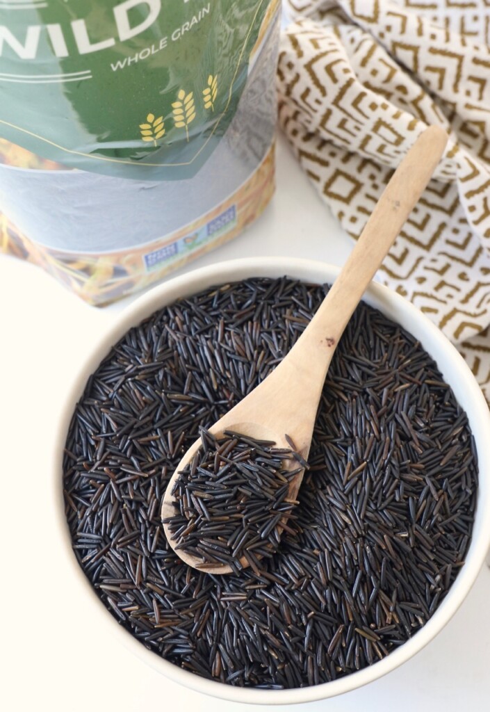 uncooked wild rice in bag and in bowl with spoon
