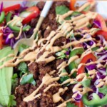 cooked vegan taco meat in bowl with vegetables topped with creamy chipotle sauce drizzle
