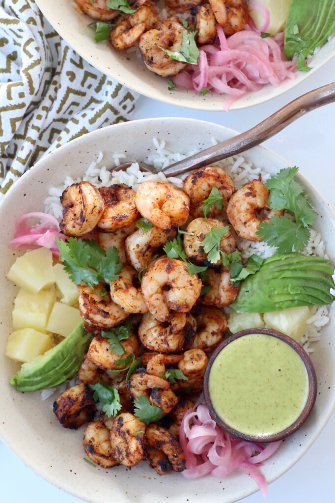 cooked shrimp in bowl with rice and sliced avocado